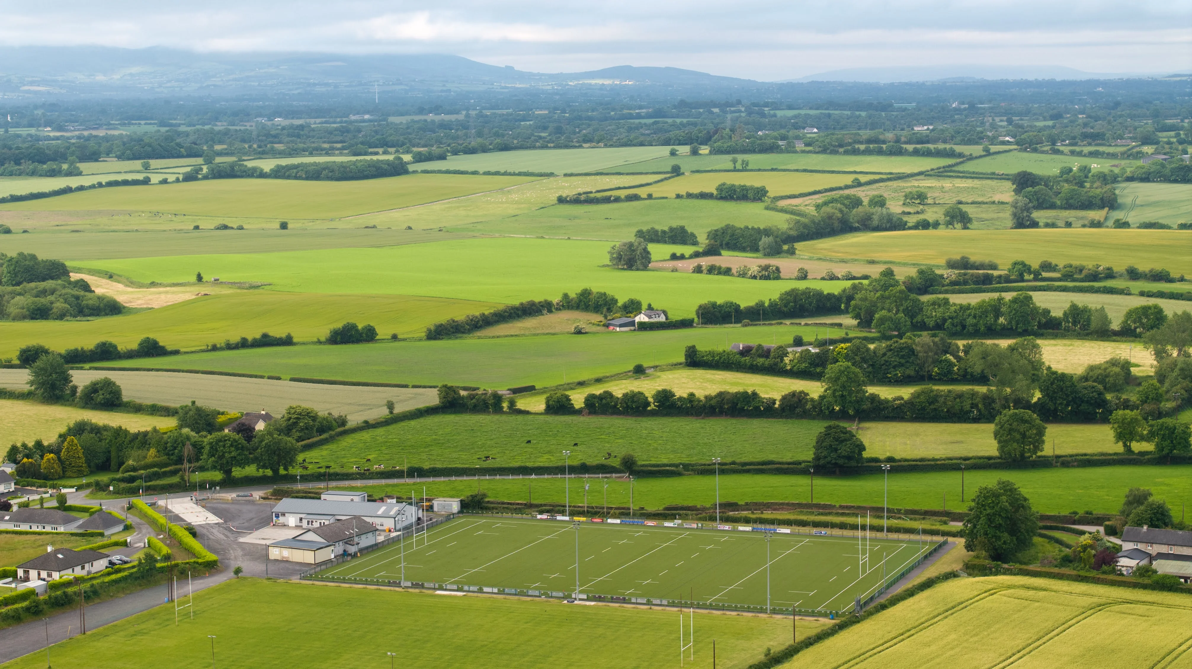 Aerial view of sports pitches and club facilities surrounded by green fields